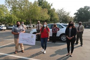 Men and women hold an oversized check.