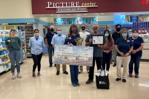 A couple holds an oversized check for $40,000 made out to Children's Miracle Network.