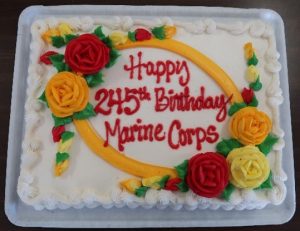 A decorated cake has the words Happy 245th Birthday Marine Corps.