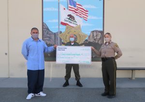 The prison population donated money to St. Jude, shown in a large check held by an inmate and two prison staff members.