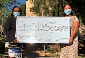 Warden Cynthia Tampkins and Dechanet Alexander hold an oversized check.