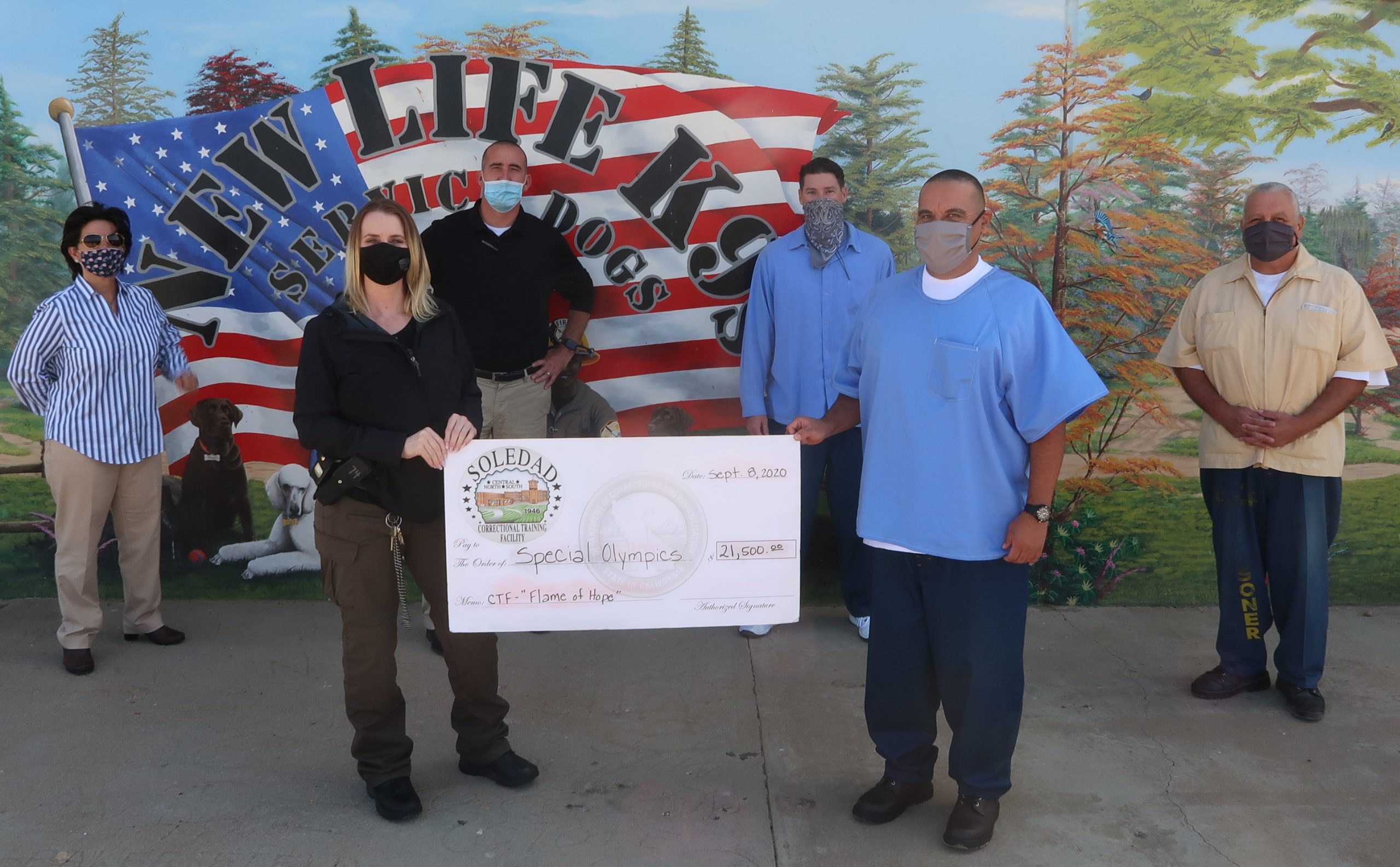 Correctional Training Facility staff and inmates hold a check.