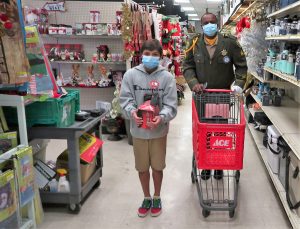 Sergeant Ward pushes a shopping cart alongside a child.
