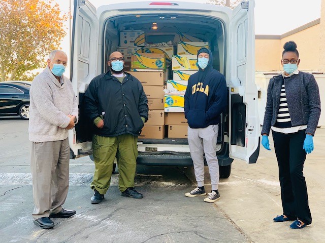 Four staff from LAC with a van full of meals.
