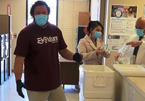 Three masked Avenal prison staff sell burritos to raise funds for Special Olympics.