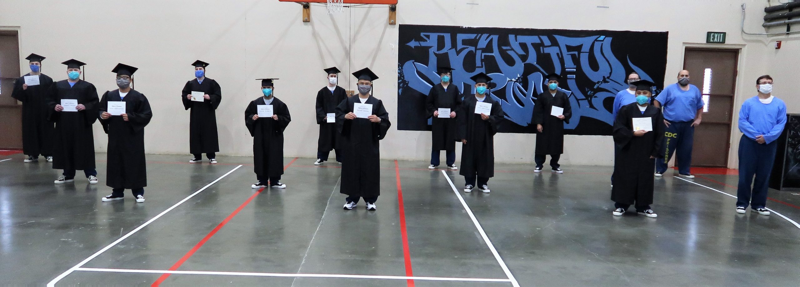Incarcerated students hold diplomas.