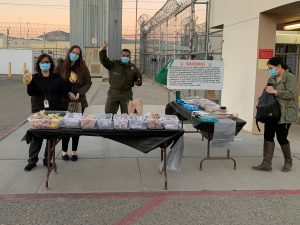 Avenal prison staff stand at tables selling baked goods.