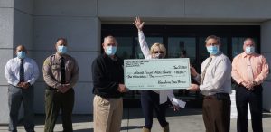 Prison staff donate a check to a veterans organization.