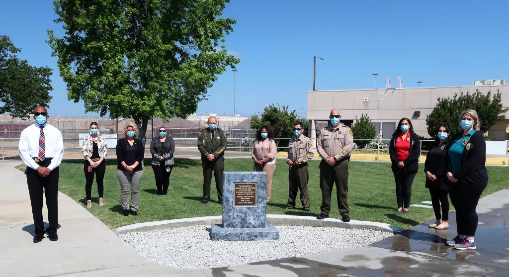 People gather around a crime victims' memorial at Valley State Prison.