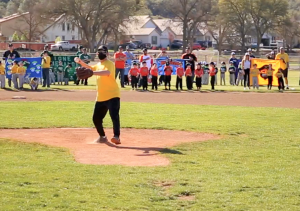 Man throws first pitch in little league game.