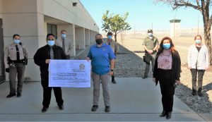 Substance Abuse Treatment Facility staff give a check to charity.