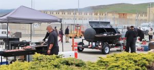 Food truck workers grill meals for CMC staff. The prison can be seen in the background.