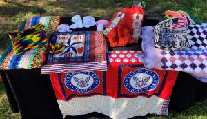 Table filled with hand-crafted clothing and blankets.