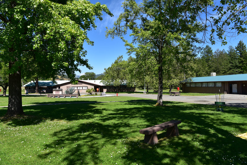 Eel River camp buildings and grassy area with benches.
