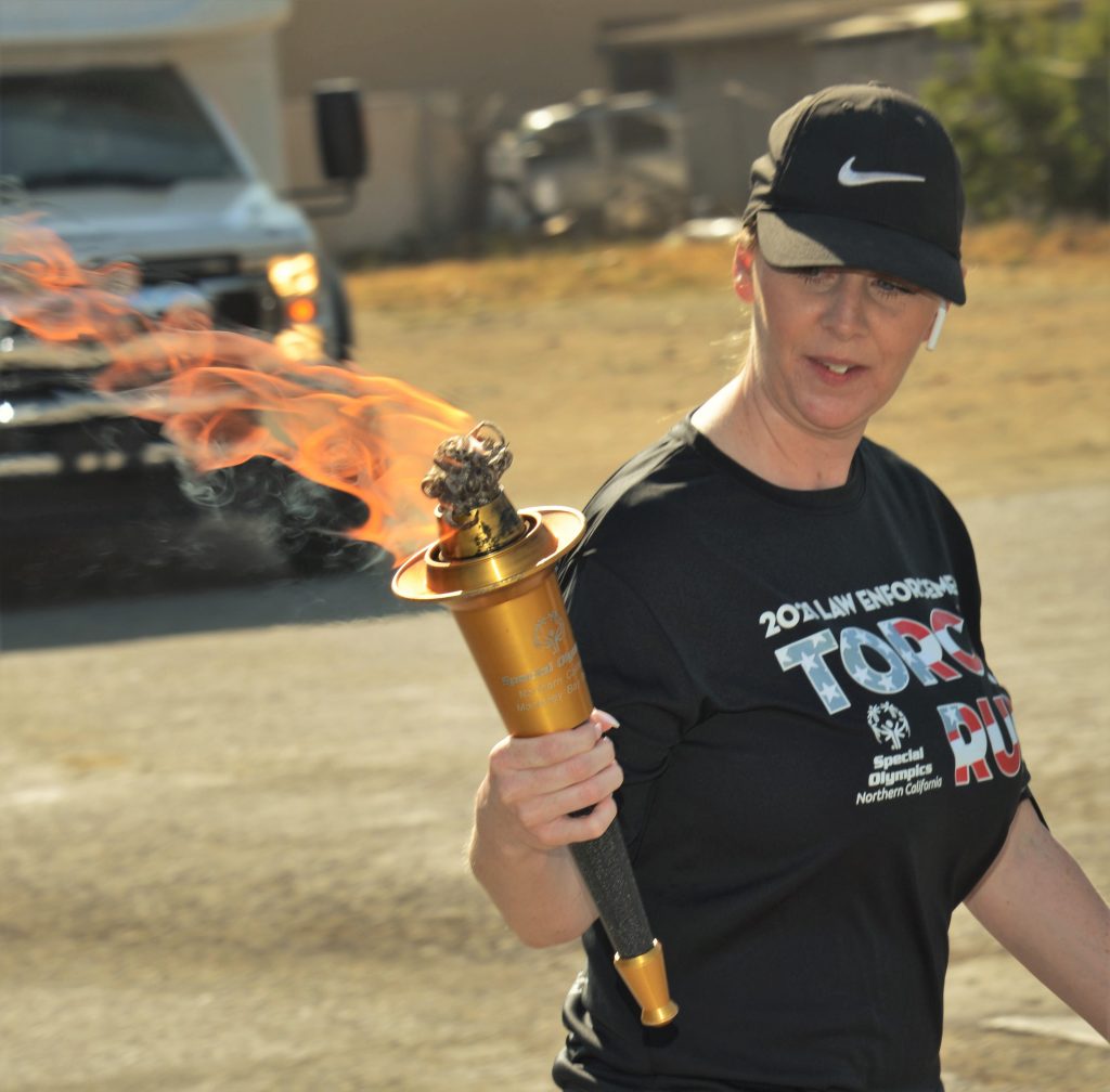 Burning Special Olympics torch carried by a runner.