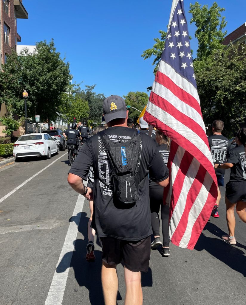 Prison staff member runs while carrying a U.S. flag.