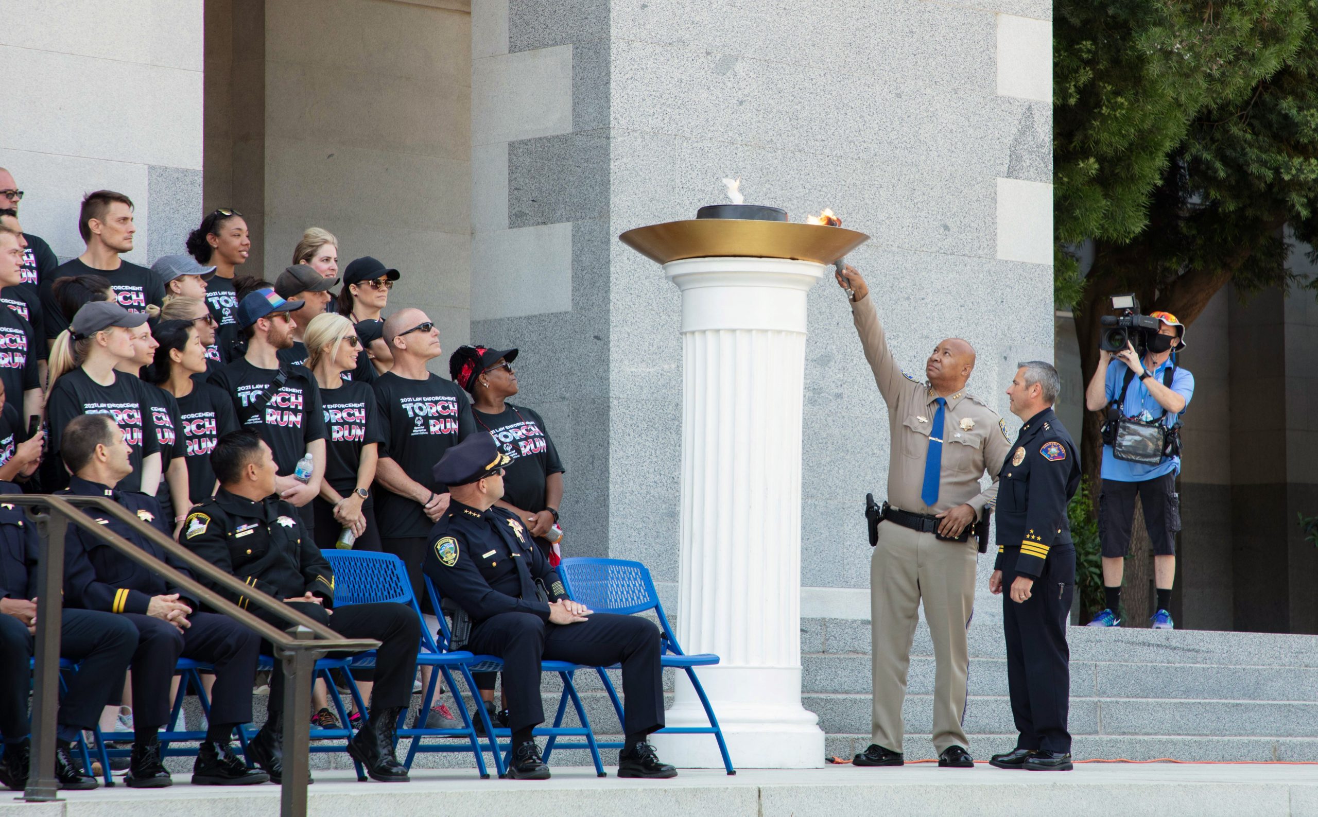 Two men light a cauldron at the end of the Special Olympics Torch Run.
