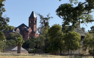Trees, a field, and Preston School of Industry Administration Building as seen from the road.