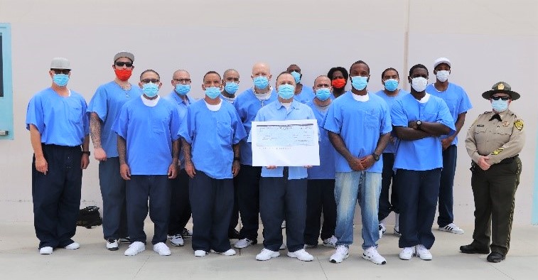Centinela prison inmates hold check for a cancer charity.