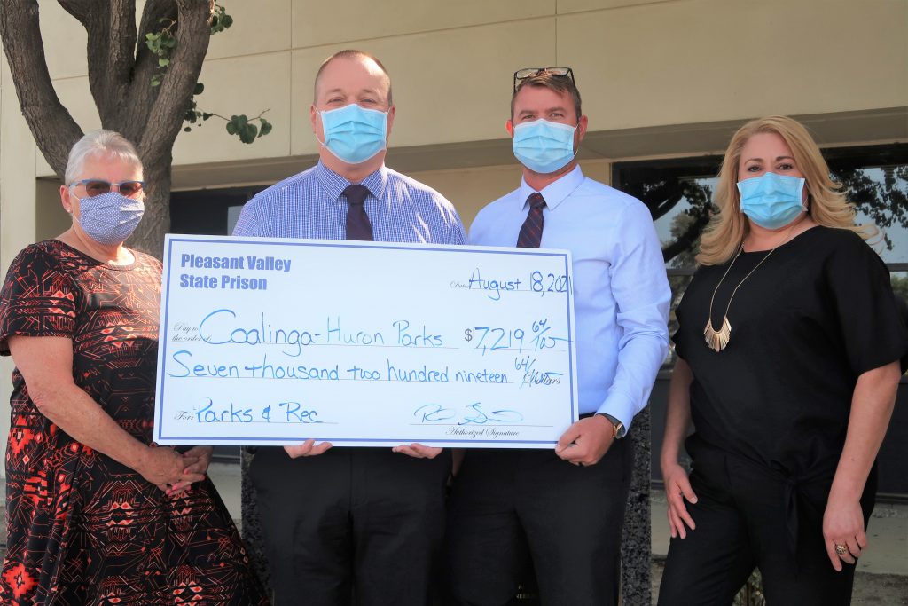 Pleasant Valley Prison staff present a check to Coalinga Parks and Recreation.