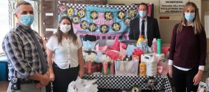CMC staff stand next to a table full of donations for Lumina Alliance.,