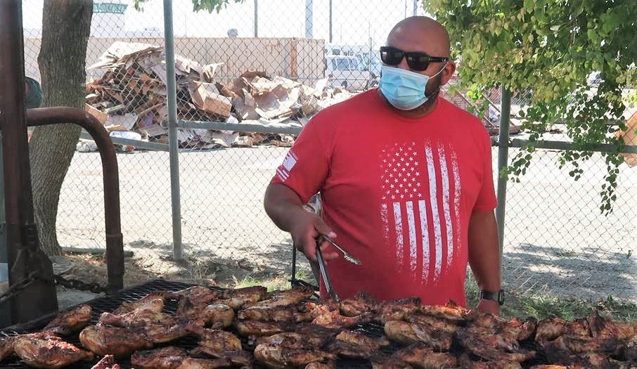Corcoran staff member works a barbecue.