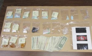 Drugs seized during search warrant are laid out on table.