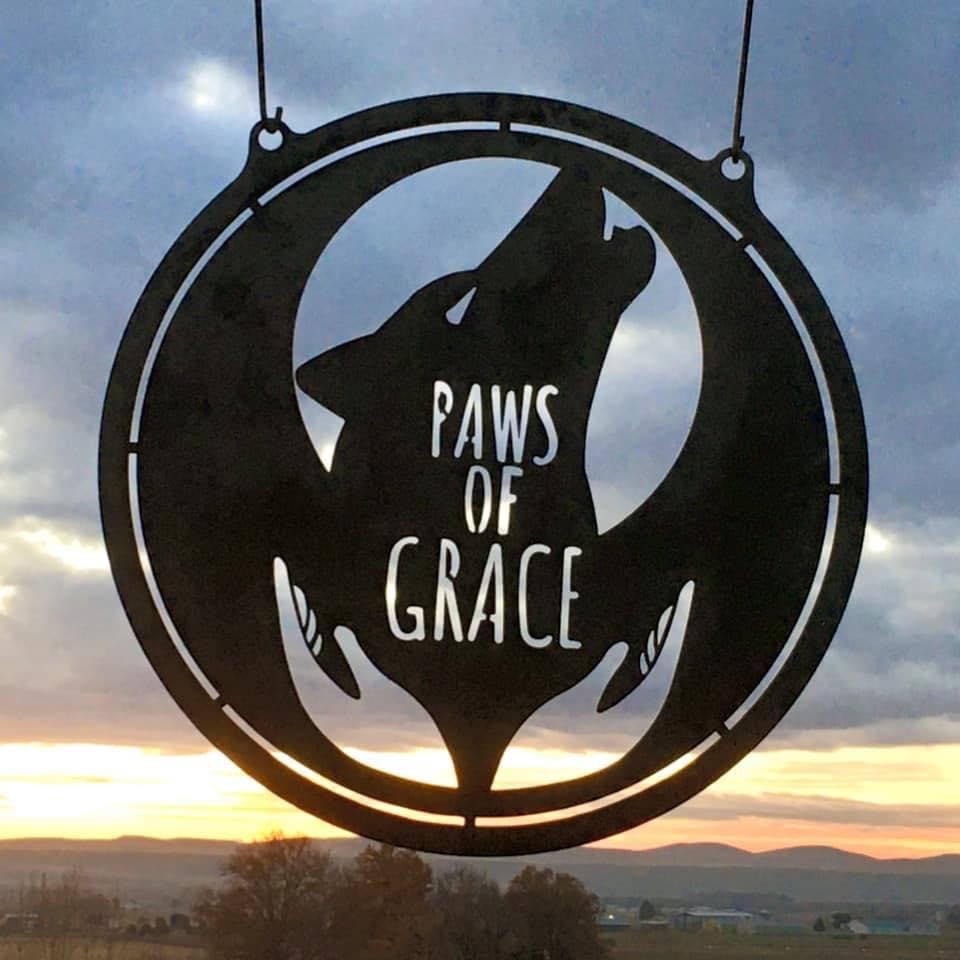 A sign with the words Paws of Grace.