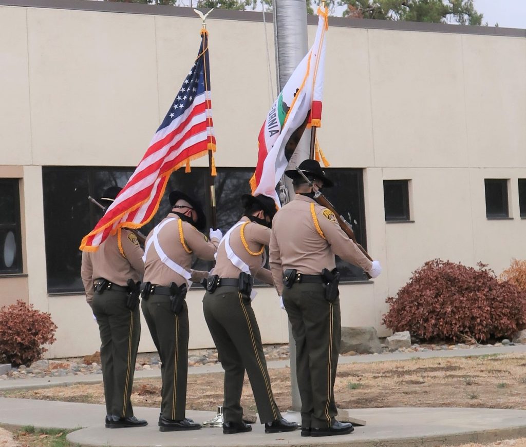 Flags and four Avenal prison honor guard members.
