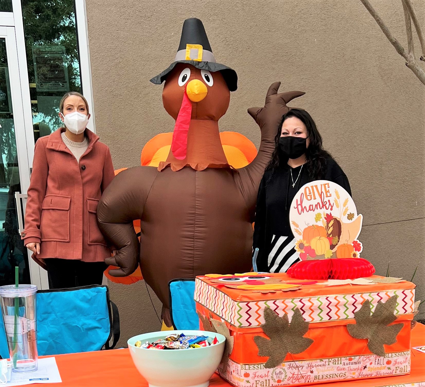 Inflatable turkey with pilgrim hat and two Office of Research employees.