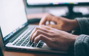 Person working on a computer keyboard.
