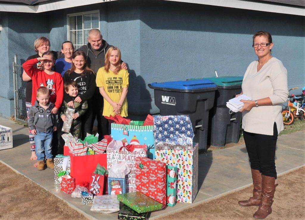 Family with gifts and a CAC staff member.