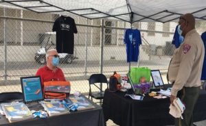 Our Promise fair California Rehabilitation Center with t-shirts, a booth and two people.
