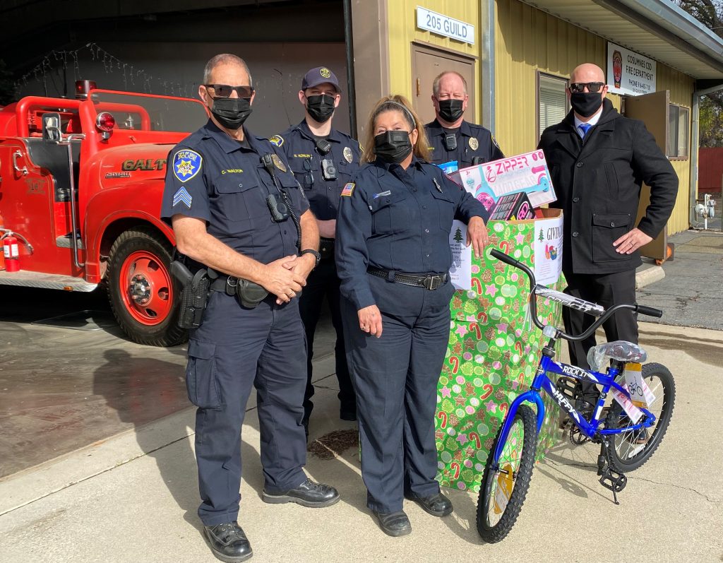Police and a fire truck along with a bicycle and gifts.