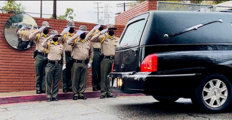 Honor Guard salutes fallen officer England as she arrives in a hearse.