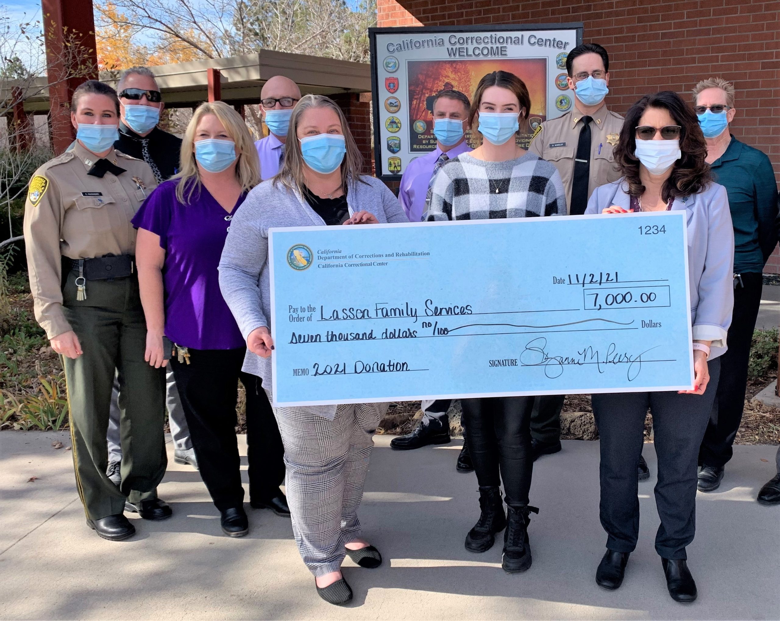 CDCR staff hold donation check.