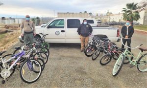 Repaired and refurbished bicycles with a City of Reedley truck and staff in background.