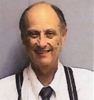 Smiling man wearing suspenders.