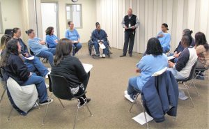 Women sit in circle at substance abuse program.