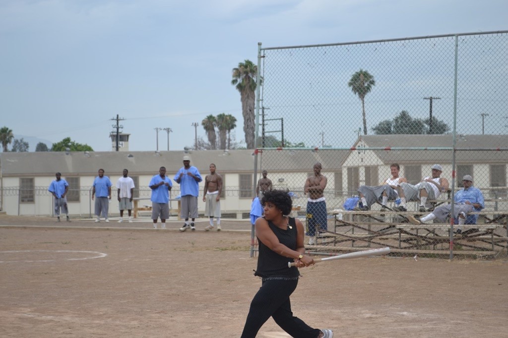 Woman swings baseball bat in a prison.