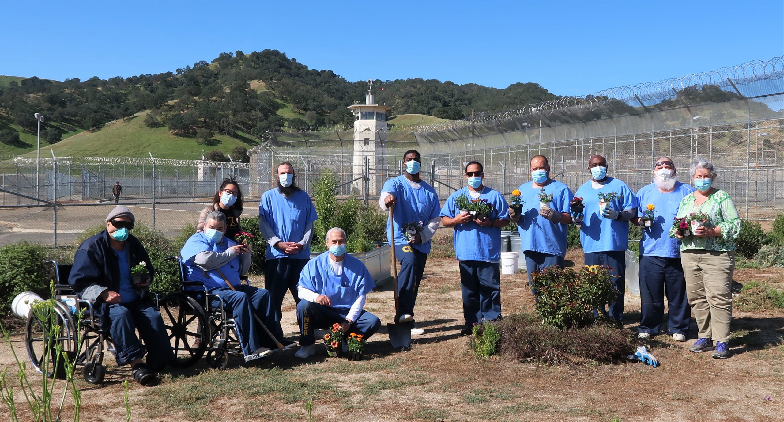 Prison Insight Garden Program participants hold plants.