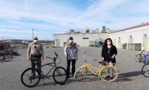 PVSP staff with bikes and framed artwork.