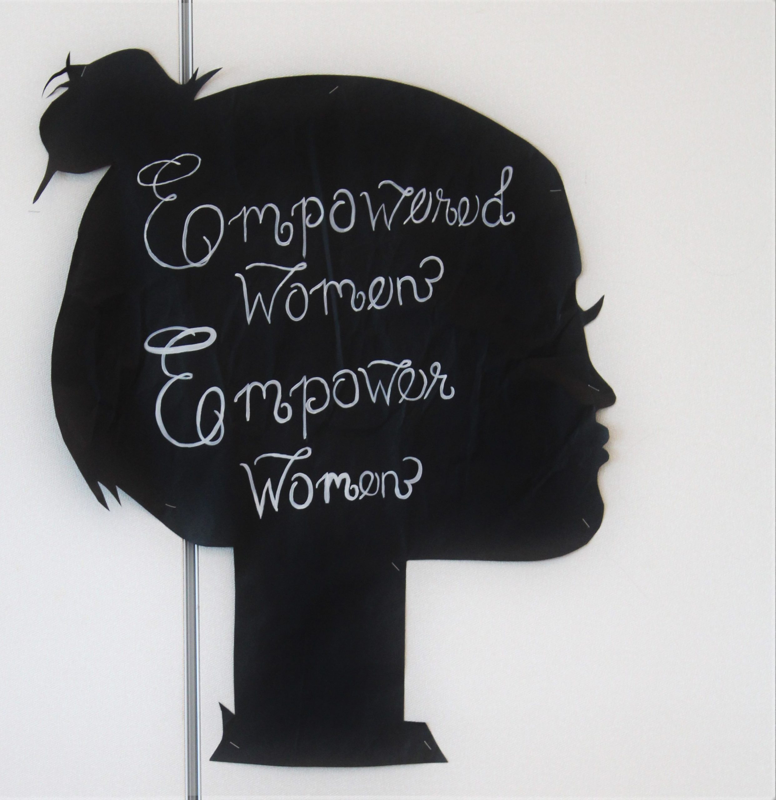 Silhouette of woman's head with writing "empowered women empower women."