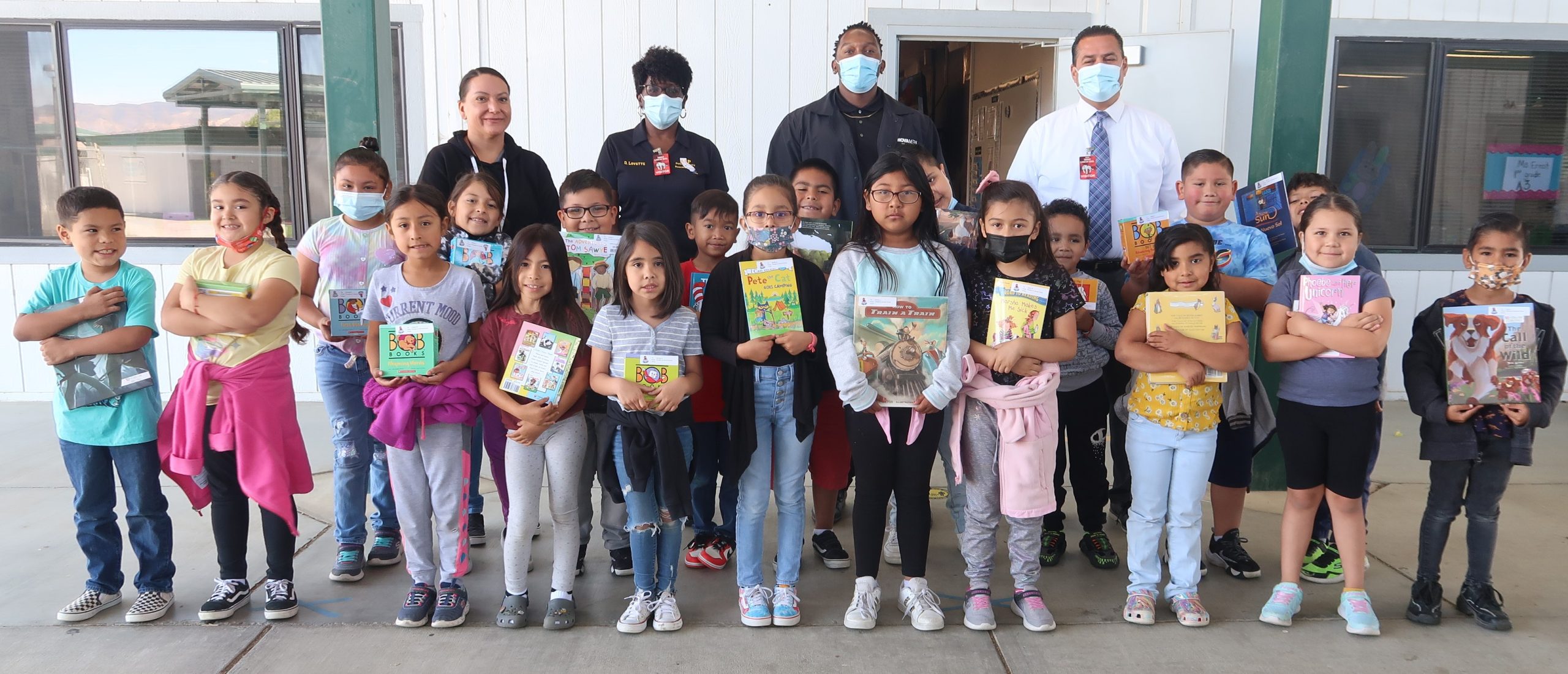 Avenal prison staff and students with books.