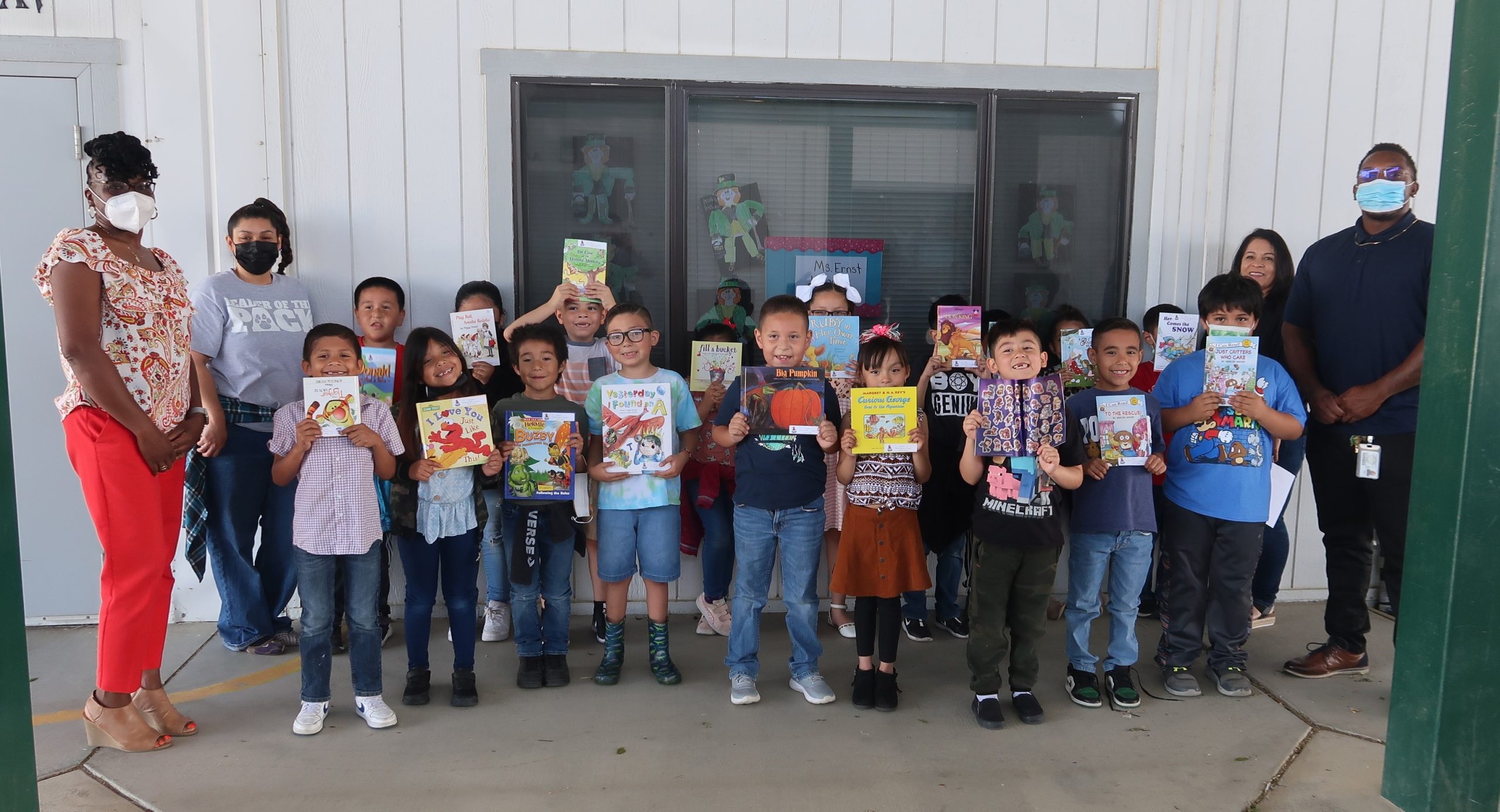 Kids hold books donated by Avenal State Prison.