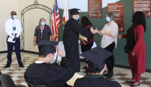 Incarcerated youth wear caps and gowns for DJJ life skills graduation.