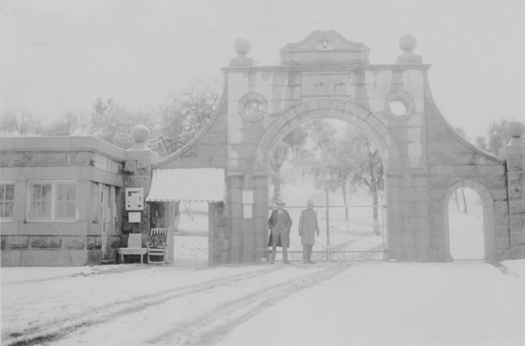 Folsom prison main gate and building with two staff and snow in 1930.