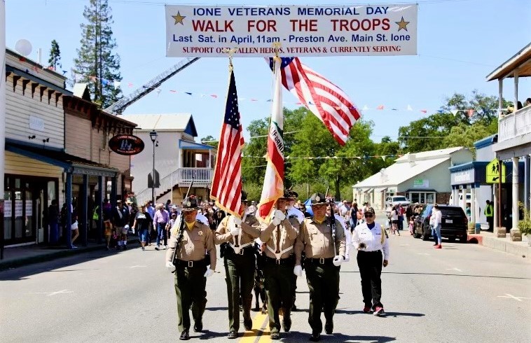 Mule Creek honor guard marches under banner for Walk for the Troops event.