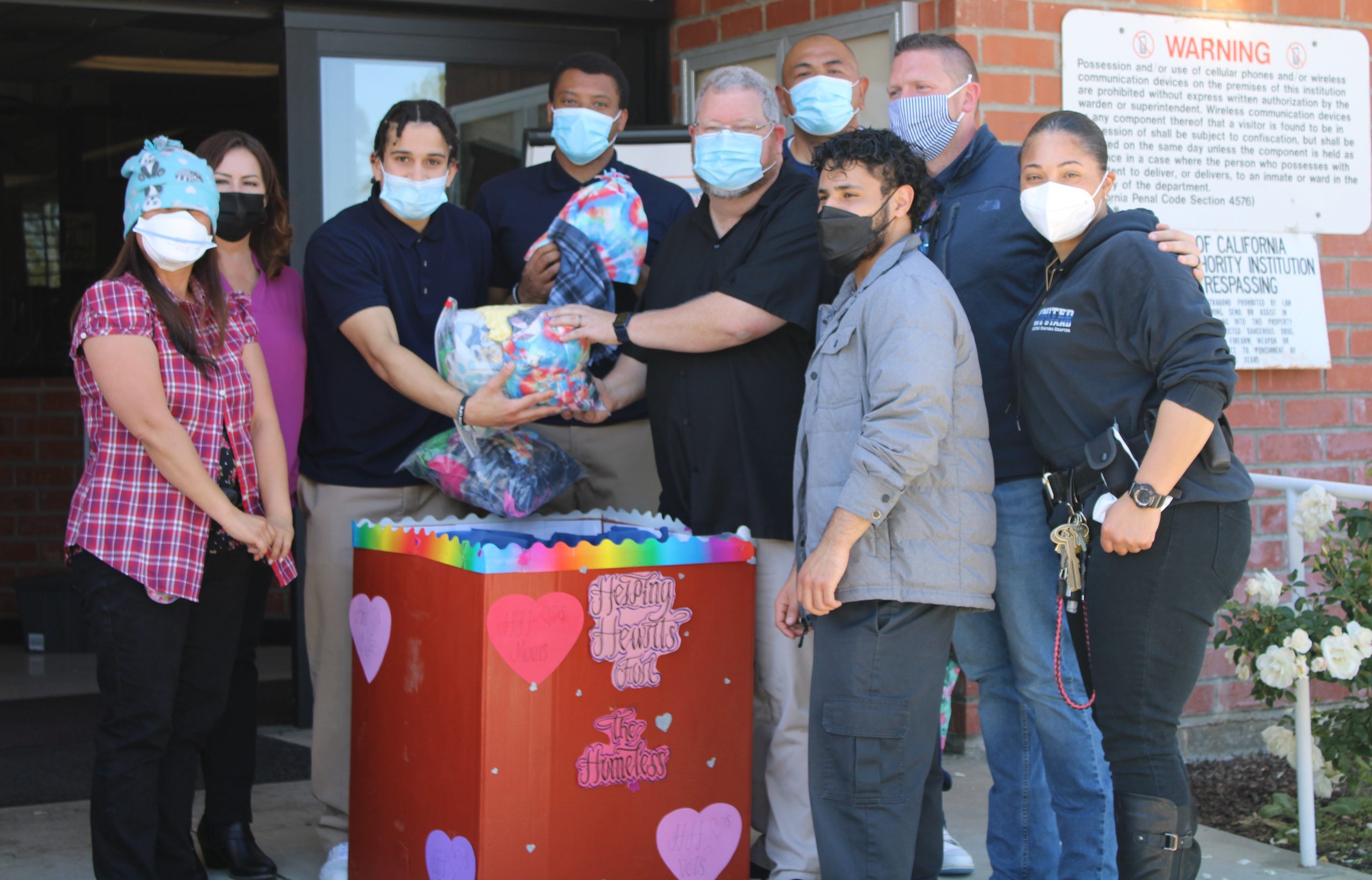 Youth and staff at correctional facility donate beanies in a box for a homeless shelter.