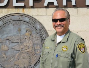 Correctional Officer Craig Lee in uniform in front of Valley State Prison sign.